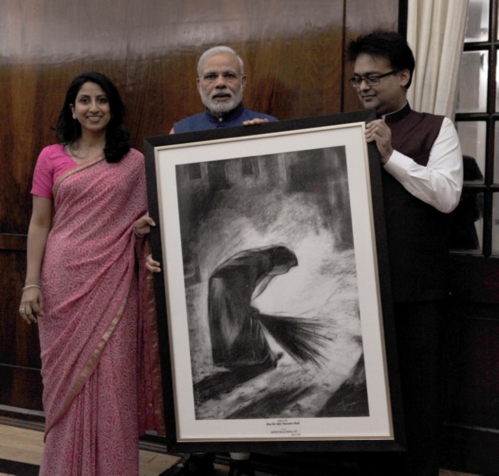 Shreya  Amish Mehta presenting Sneha Mehtas artwork The Sweeper to Narendra Modi